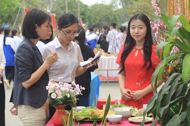 Description: A group of women standing around a table with food Description automatically generated